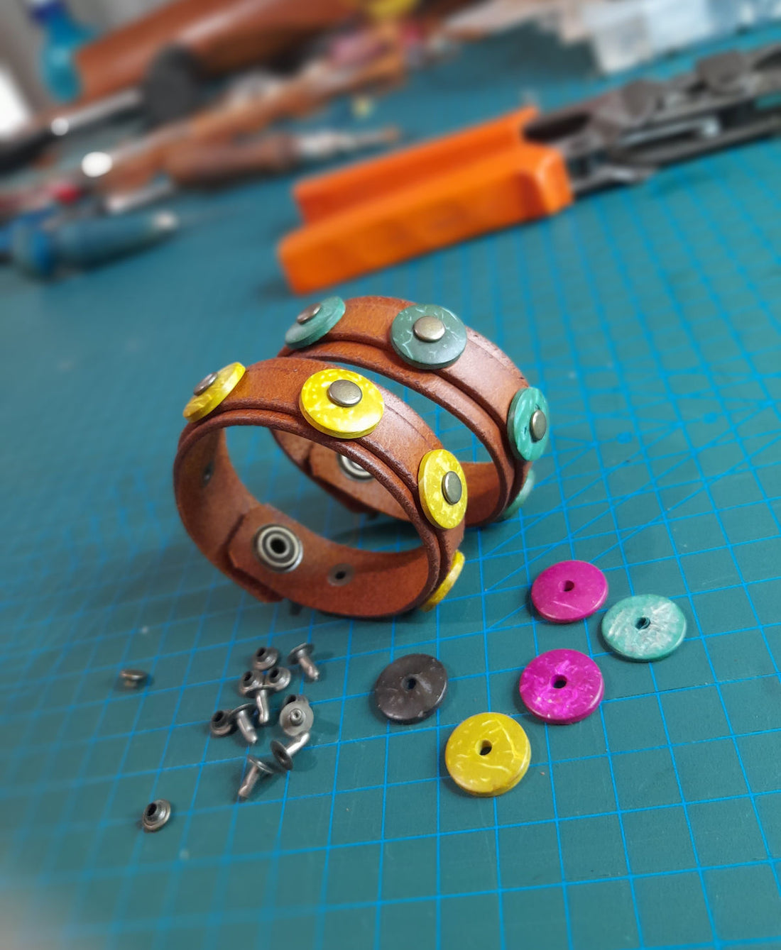 two handmade matching leather bracelets, decorated with colorful coconut donut beads