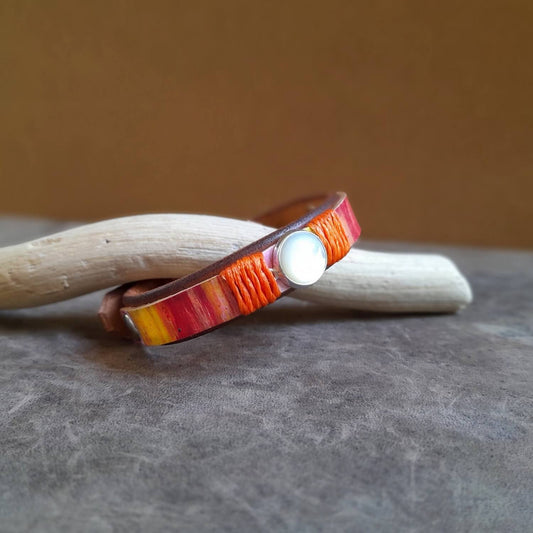 The OOAK 90's Pop Moonstone Bracelet: A hand-painted full-grain leather cuff in vibrant orange, yellow, and pink hues, featuring a natural Moonstone set on a sterling silver pendant.