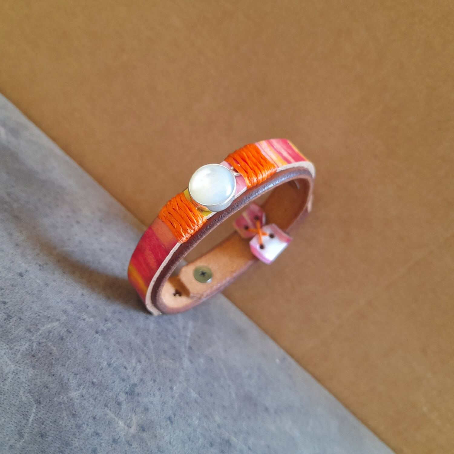 Close-up side view showing the hand-painted acrylic details on the two-layered Vachetta leather band of the 90's Pop Bracelet, emphasizing the vibrant colors and sealed finish.