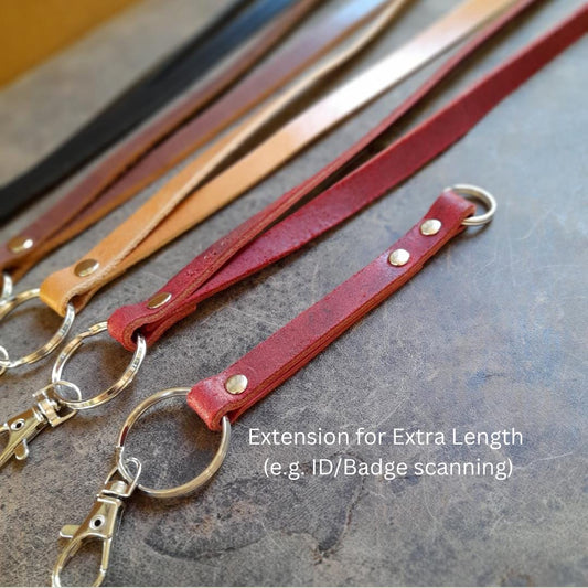 A group photo of The Adapt Lanyard in all four available timeless colors: Burgundy Red, Black, Warm Brown, and Dark Brown, showcasing the full range of oiled vachetta leather options, focusing on the removable extension.