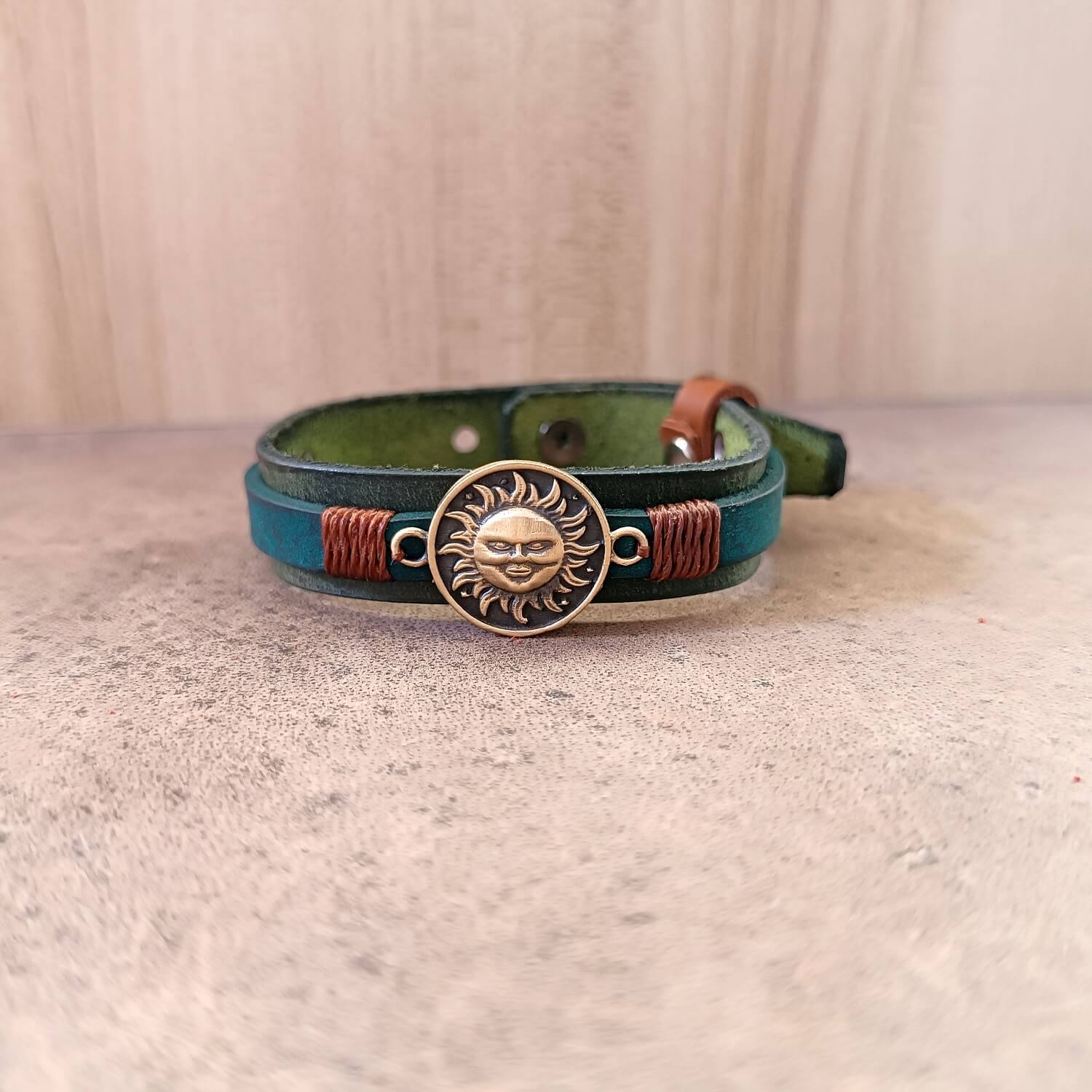 Leather bracelet with sun emblem on a textured surface