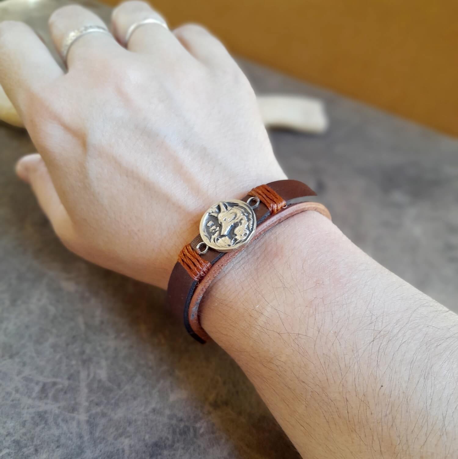 Arctic Fox Leather Bracelet worn on a woman's wrist, showcasing its elegant design and the detailed brass fox charm. Handmade by Lucky Seven Leather.