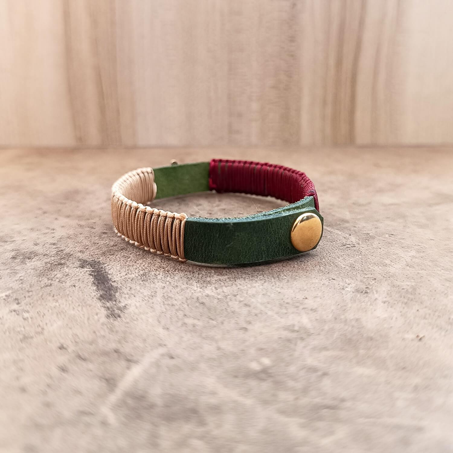 Back view of The Hamsa Harmony Bracelet, displaying the gold stainless steel snap button closure and the adjustable settings on the khaki leather band.