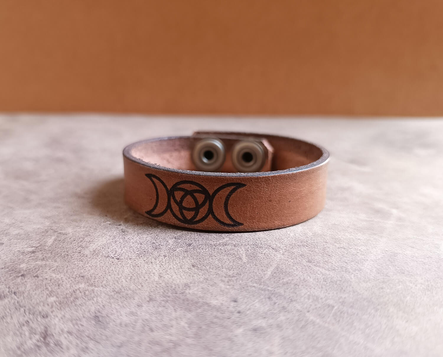 Brown Leather bracelet with engraved triple moon design close up