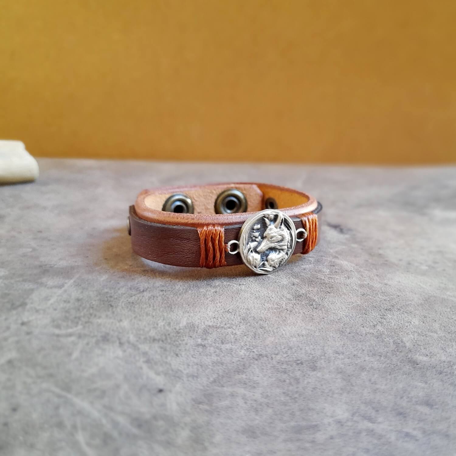 Close-up of Arctic Fox Leather Bracelet, highlighting the intricate details of the oxidized brass fox charm and the rich texture of the layered vachetta leather.