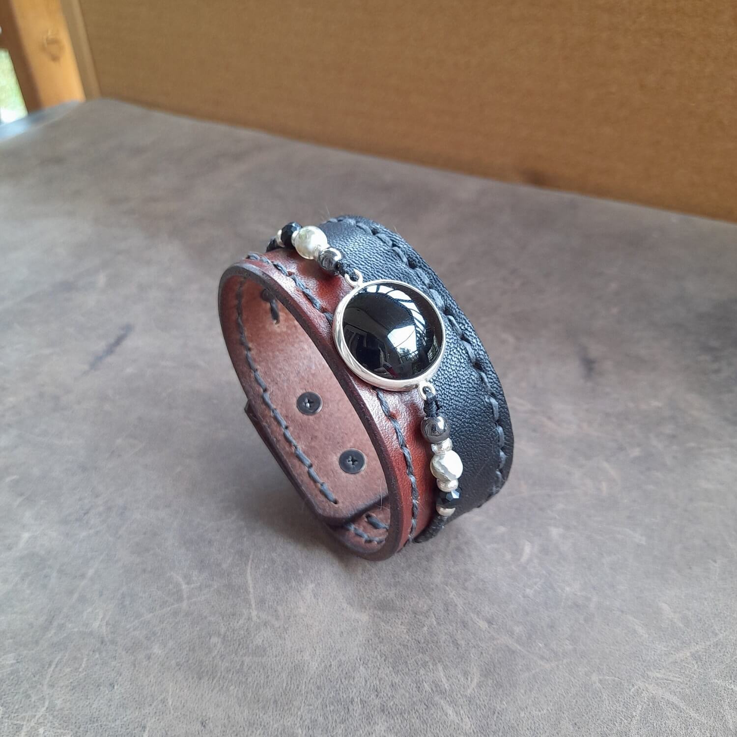 Close-up of Black Obsidian & Silver Cabochon:Detailed close-up of the natural black obsidian stone on its hand-polished sterling silver 925 cabochon on the Obsidian Power Cuff.