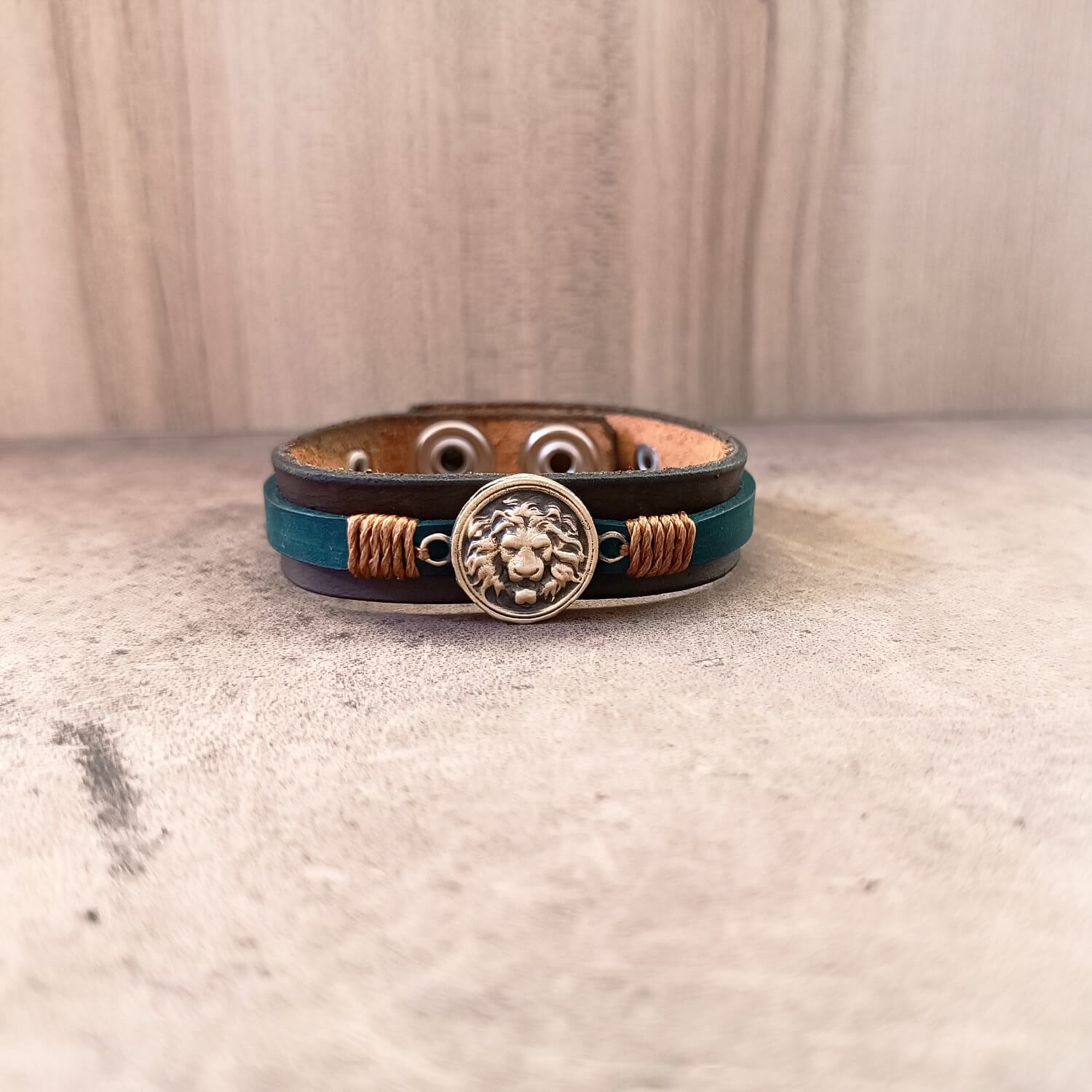 Leather bracelet with lion emblem on a textured surface