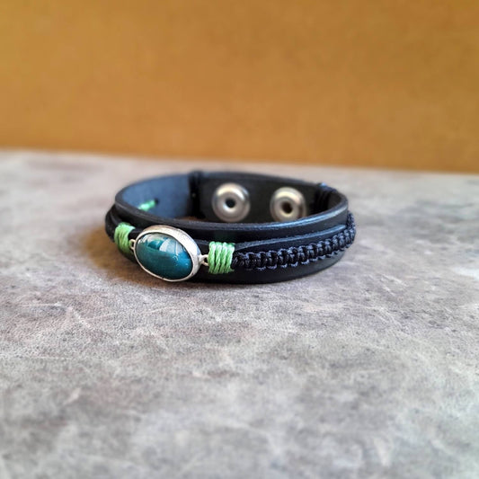 The OOAK Green Aventurine Black Leather Bracelet: A layered black Vachetta leather cuff with black macramé, featuring a prominent natural dark green Aventurine stone set in a sterling silver pendant.