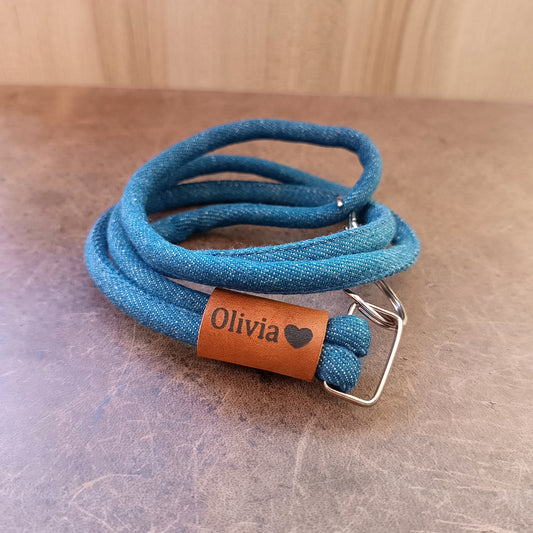 Close-up of the Crazy Horse leather accent on the Personalized Denim & Leather Lanyard, clearly showing a custom laser engraving and the metal D-ring and clasp.