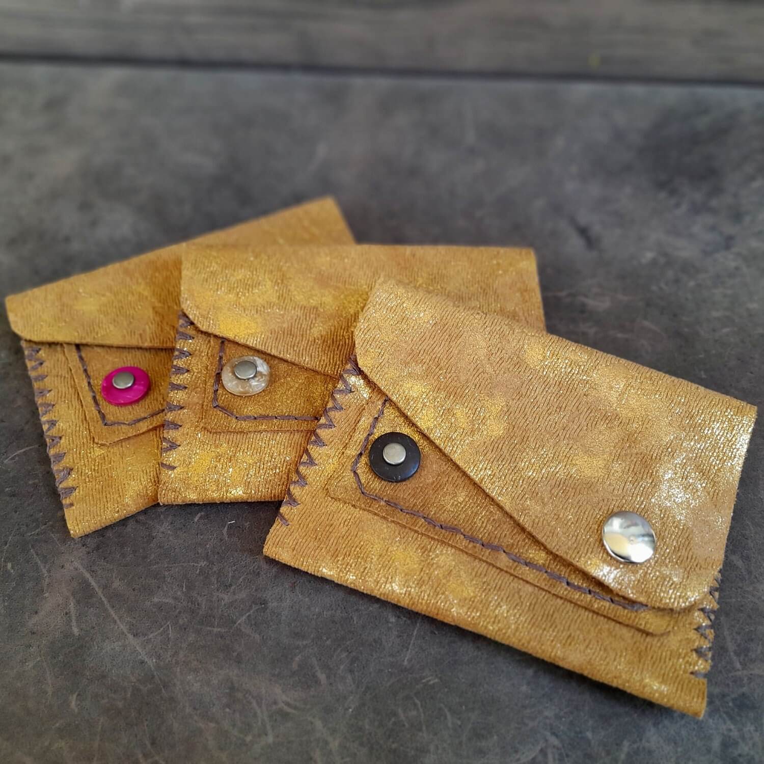 Close-up of the Gold upcycled leather mini wallets, showcasing their compact size, texture, and elegant appearance.