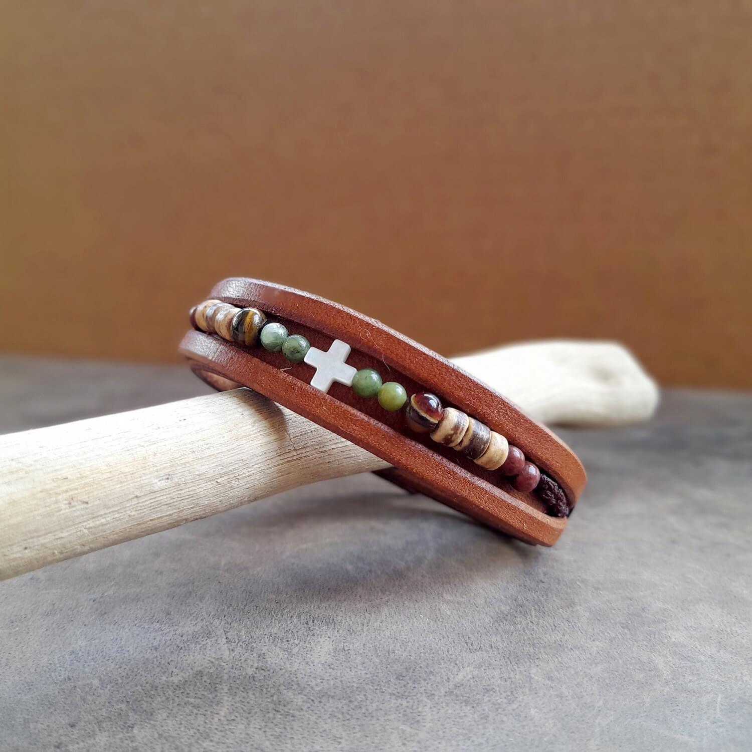 Close-up of the ivory cross and natural beads on the leather bracelet.