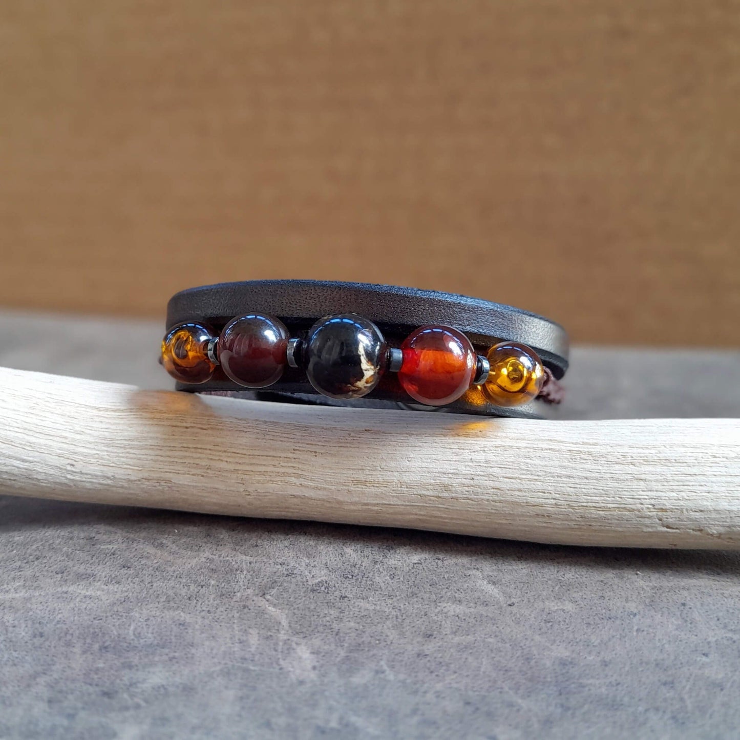 Detailed close-up of the natural Amber and Carnelian gemstone beads, highlighting their colors and textures, woven with macramé.