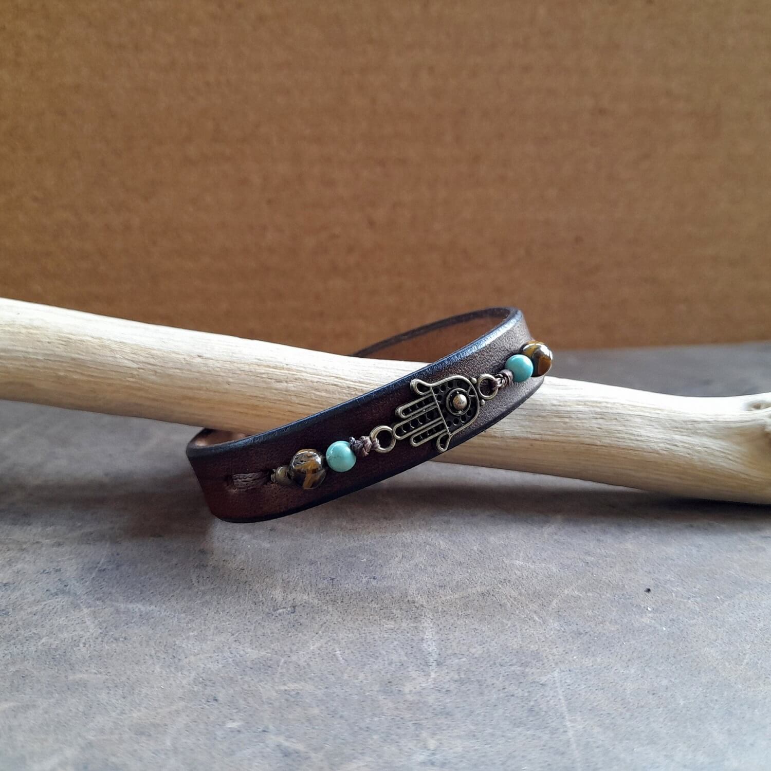 Detailed close-up of the Hamsa Hand charm on the bracelet, with green Turquoise and Tiger's Eye beads, highlighting their color and detail.