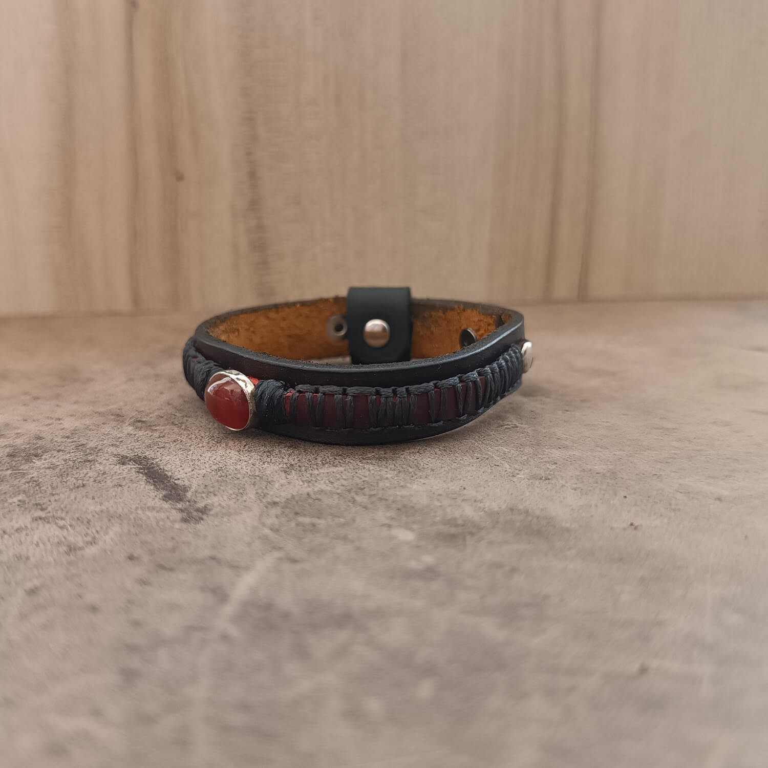Close-up side view of the layered dark brown/black and braided crimson red Crazy Horse leather on The Roamer Bracelet, emphasizing the texture and craftsmanship.