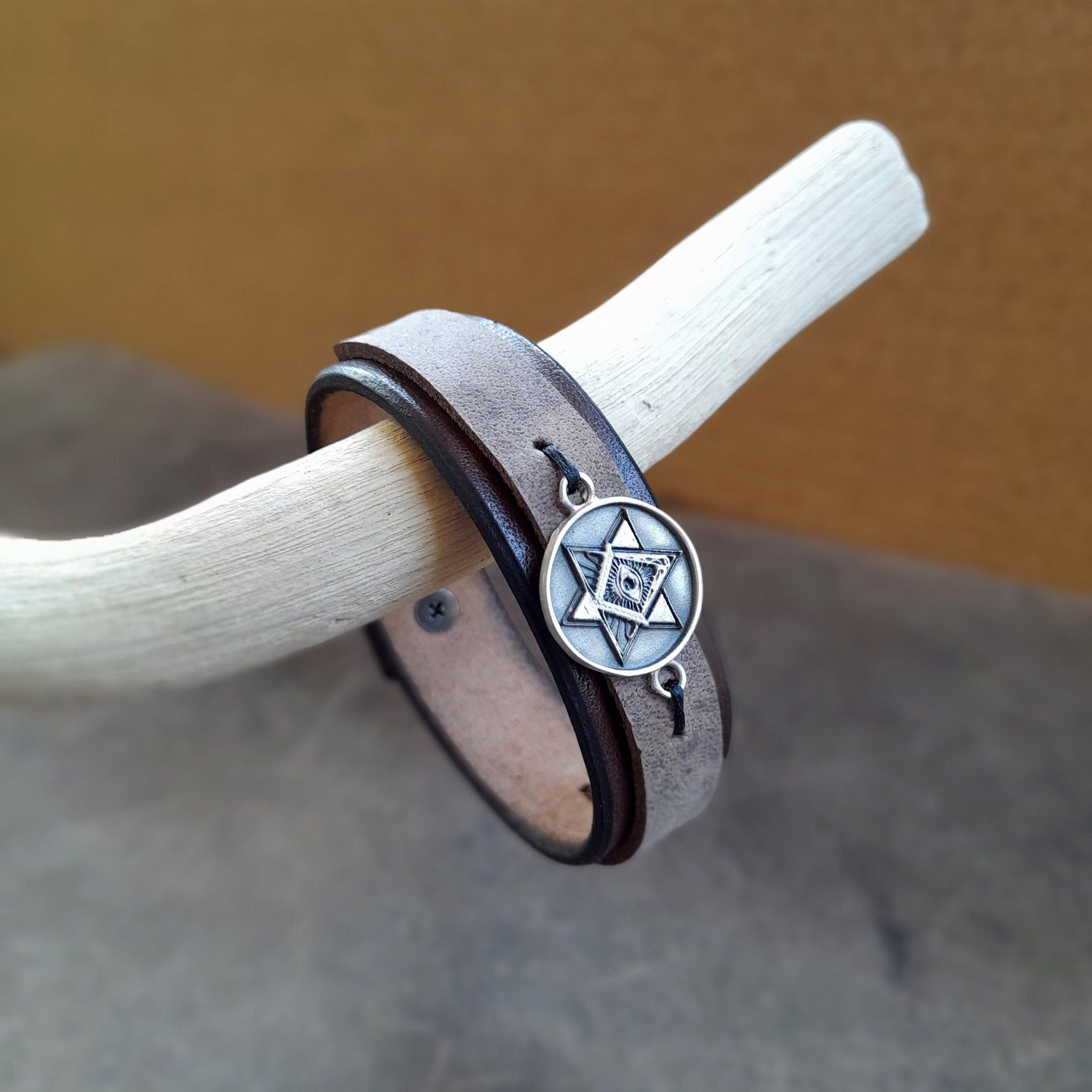 Close-up side view showing the layered chestnut brown and charcoal full-grain leather, emphasizing the material texture and the fine polished edges.