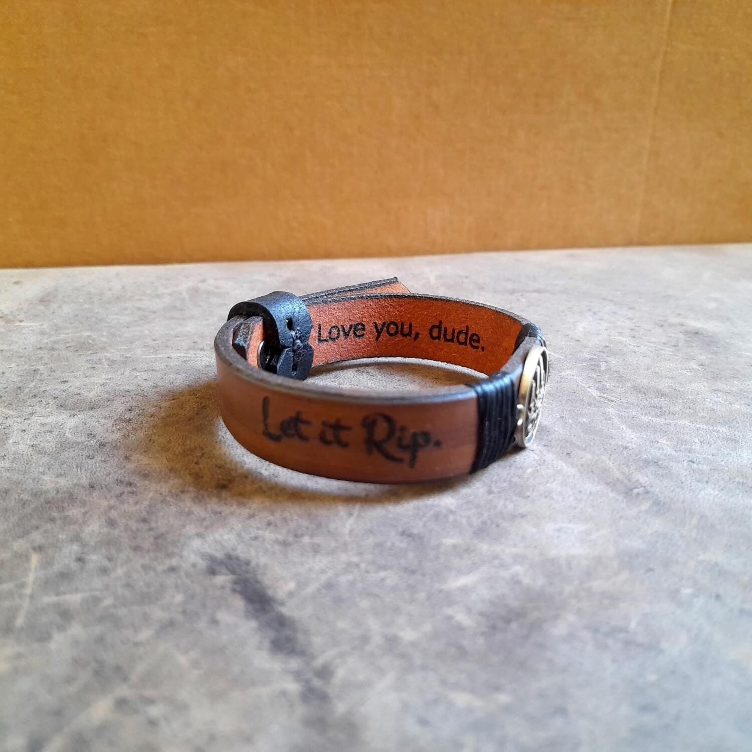 View of the inside of The Bear's Resolve Cuff, showing the "Love you, Dude" engraving in a gentle font, or an example of custom internal text on the soft leather.