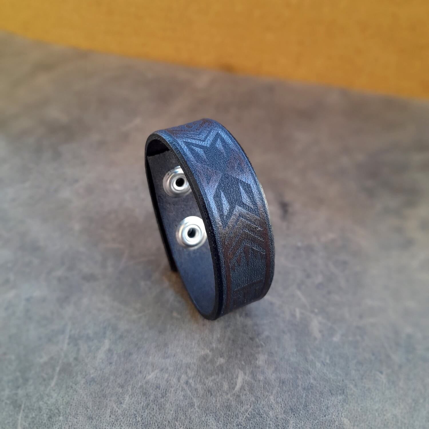 Dark brown and black Polynesian Tribal leather bracelet, showcasing engraved pattern.