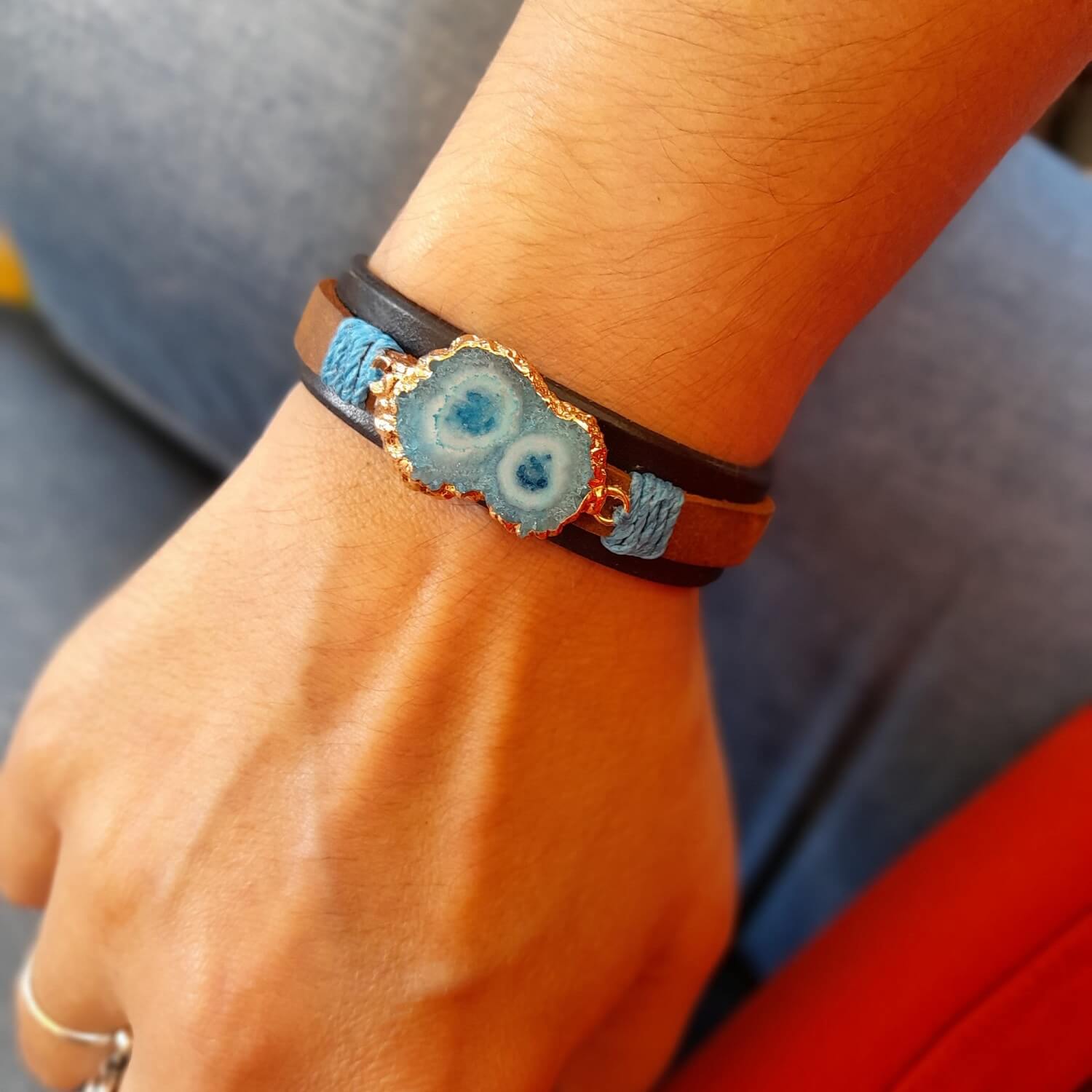 The Druzy Chrysocolla Leather Bracelet worn on a wrist, demonstrating its comfortable fit, layered design, and how it complements a casual outfit.