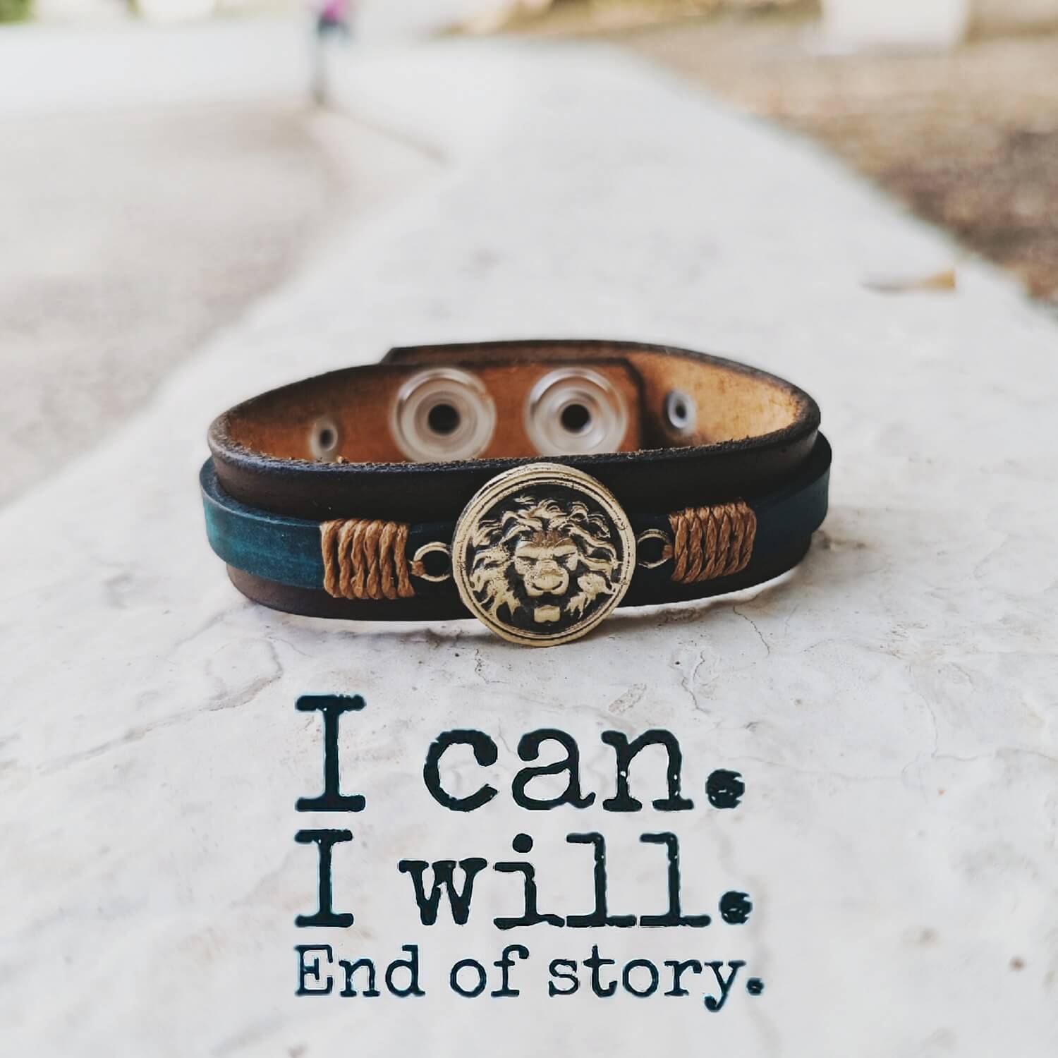 Leather bracelet with decorative elements on a textured surface with motivational quote