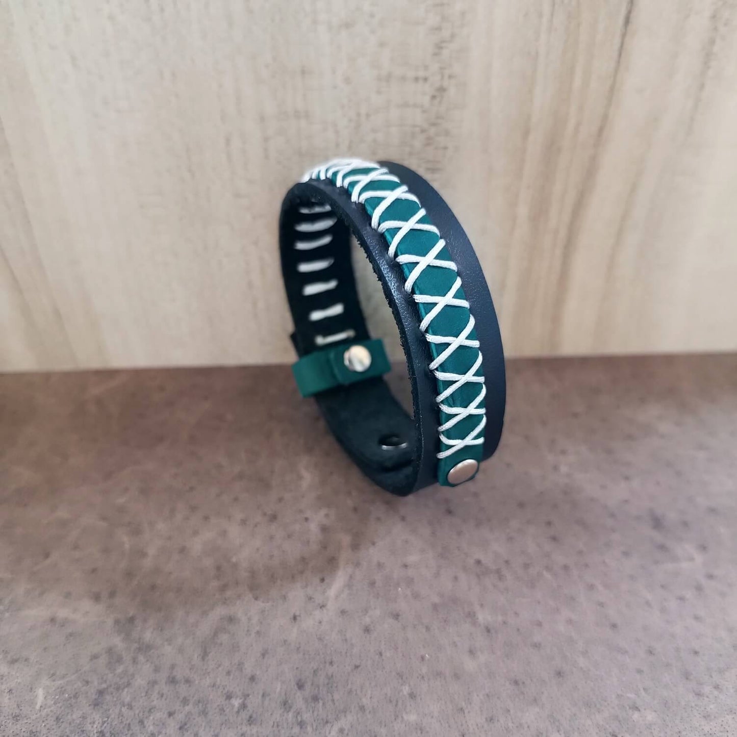 Navy Blue and teal woven bracelet on a wooden surface