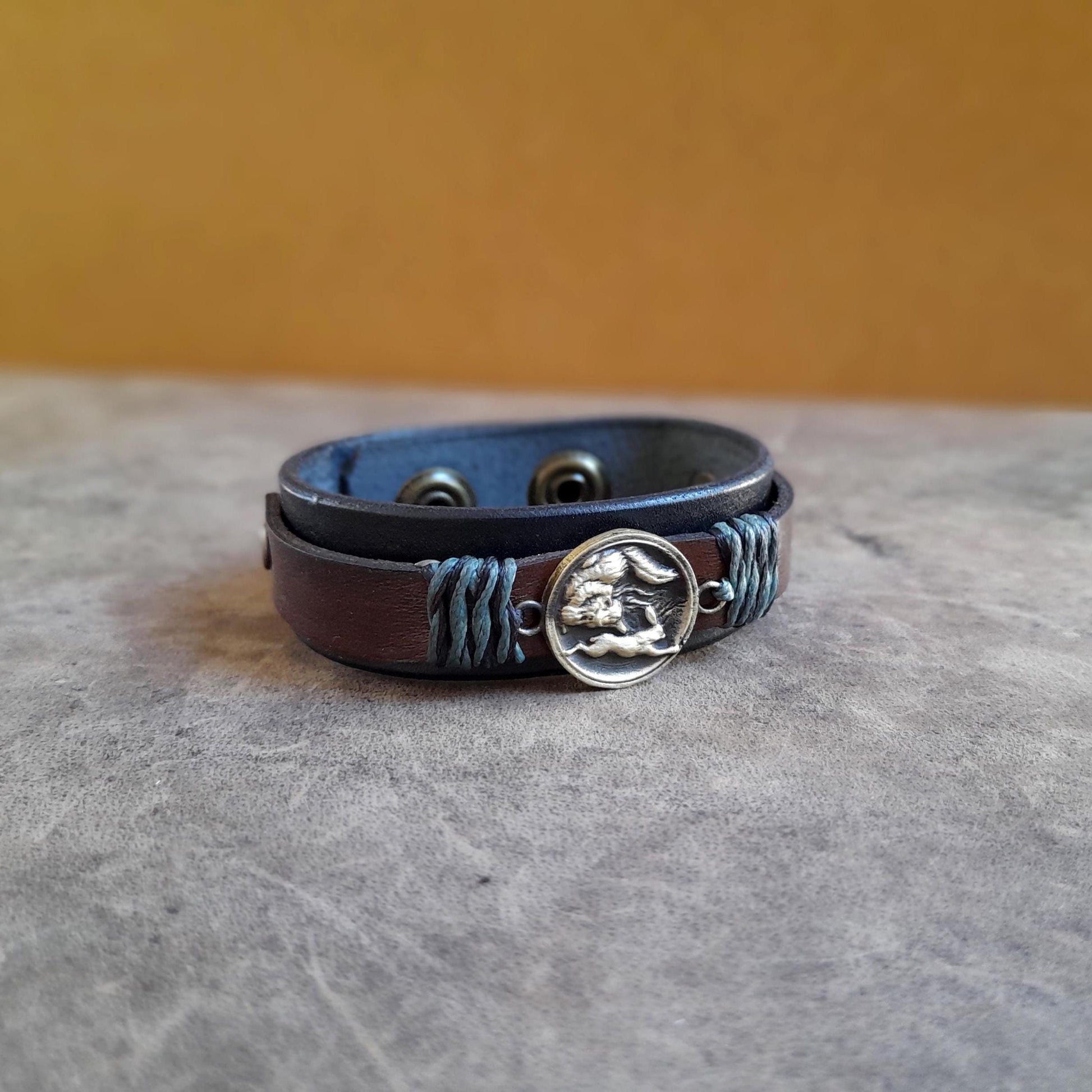 Hunting Wolf leather cuff with brass pendant and layered leather design flat view