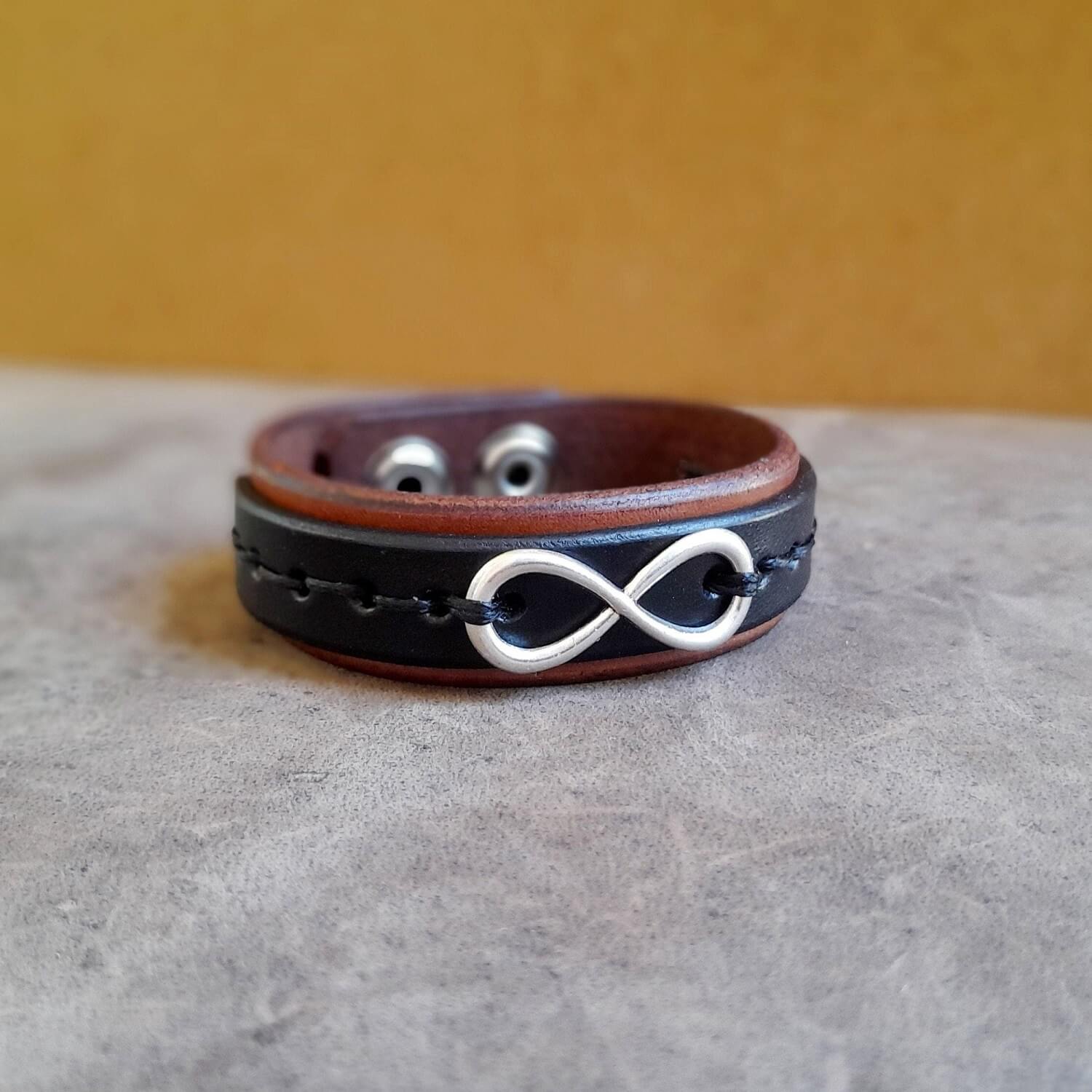 Leather bracelet with an infinity symbol on a textured surface