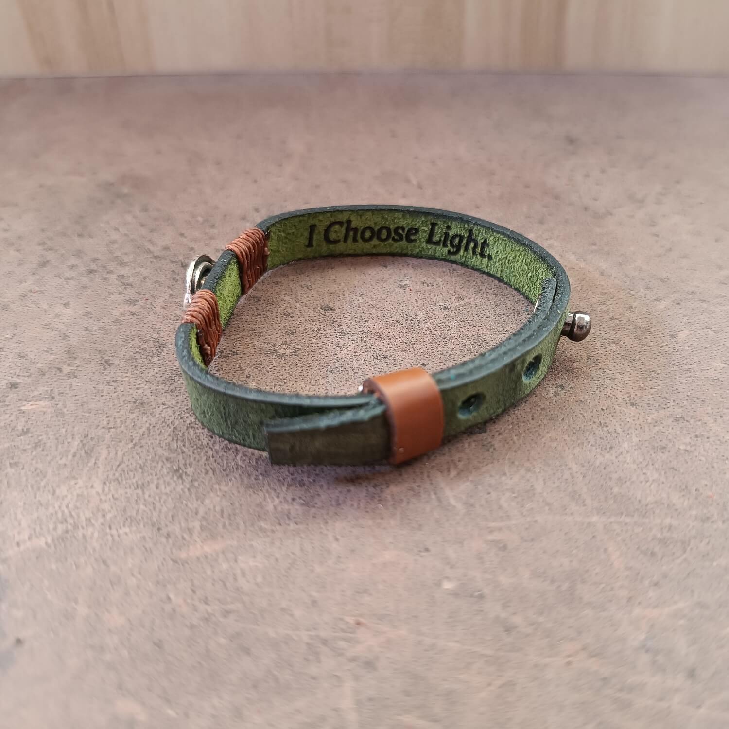 Inner Anchor Bracelet - Spiral design. Handcrafted on olive green Crazy Horse leather, symbolizing growth and inner journey, side view showing underside engraved area with message reading: I choose light.