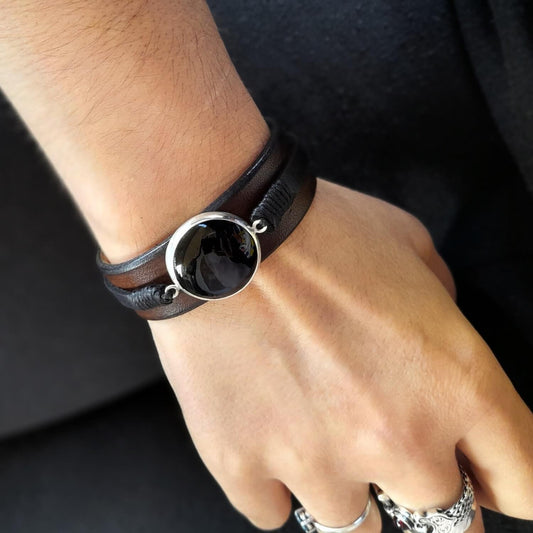 The Large Black Obsidian Leather Cuff worn on a wrist, demonstrating its substantial size, elegant fit, and versatile appeal for men and women.