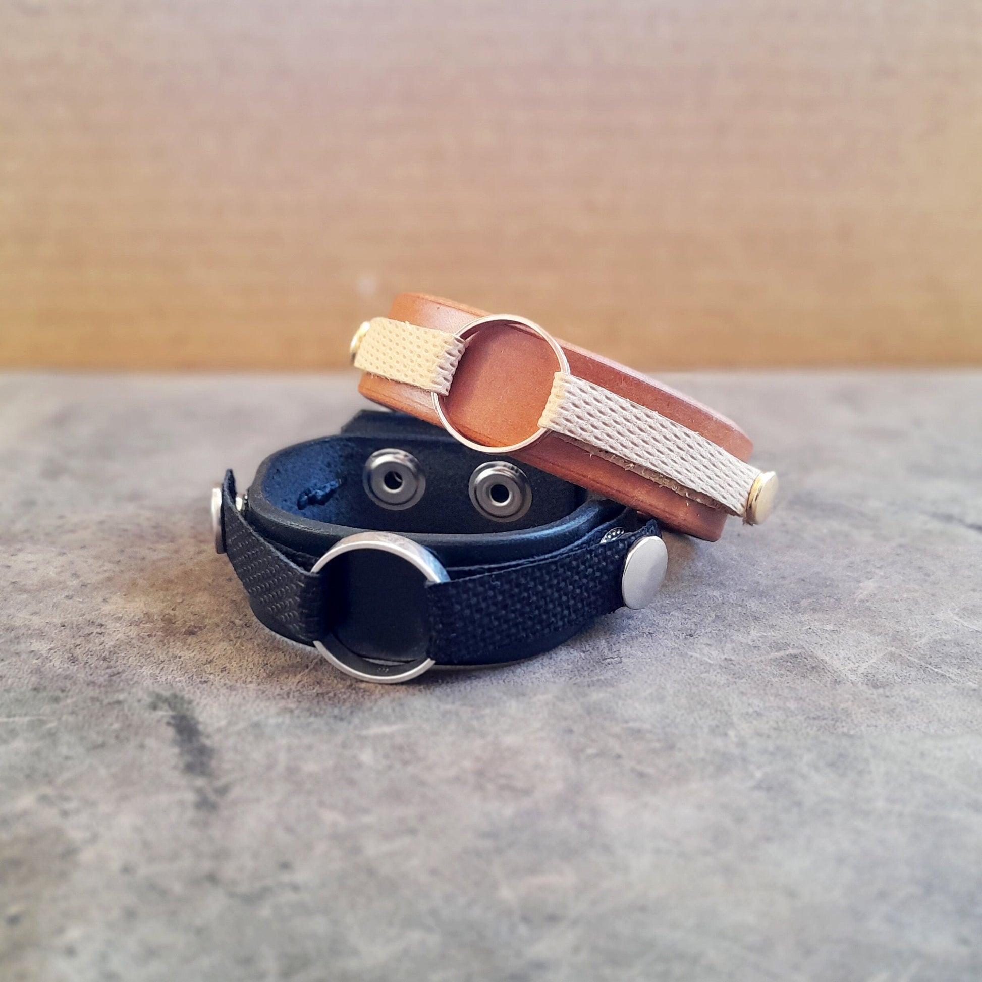 Leather Ring Holder Bracelets in black and mustard brown, with gold and silver snap buttons to match their carried ring metal color.