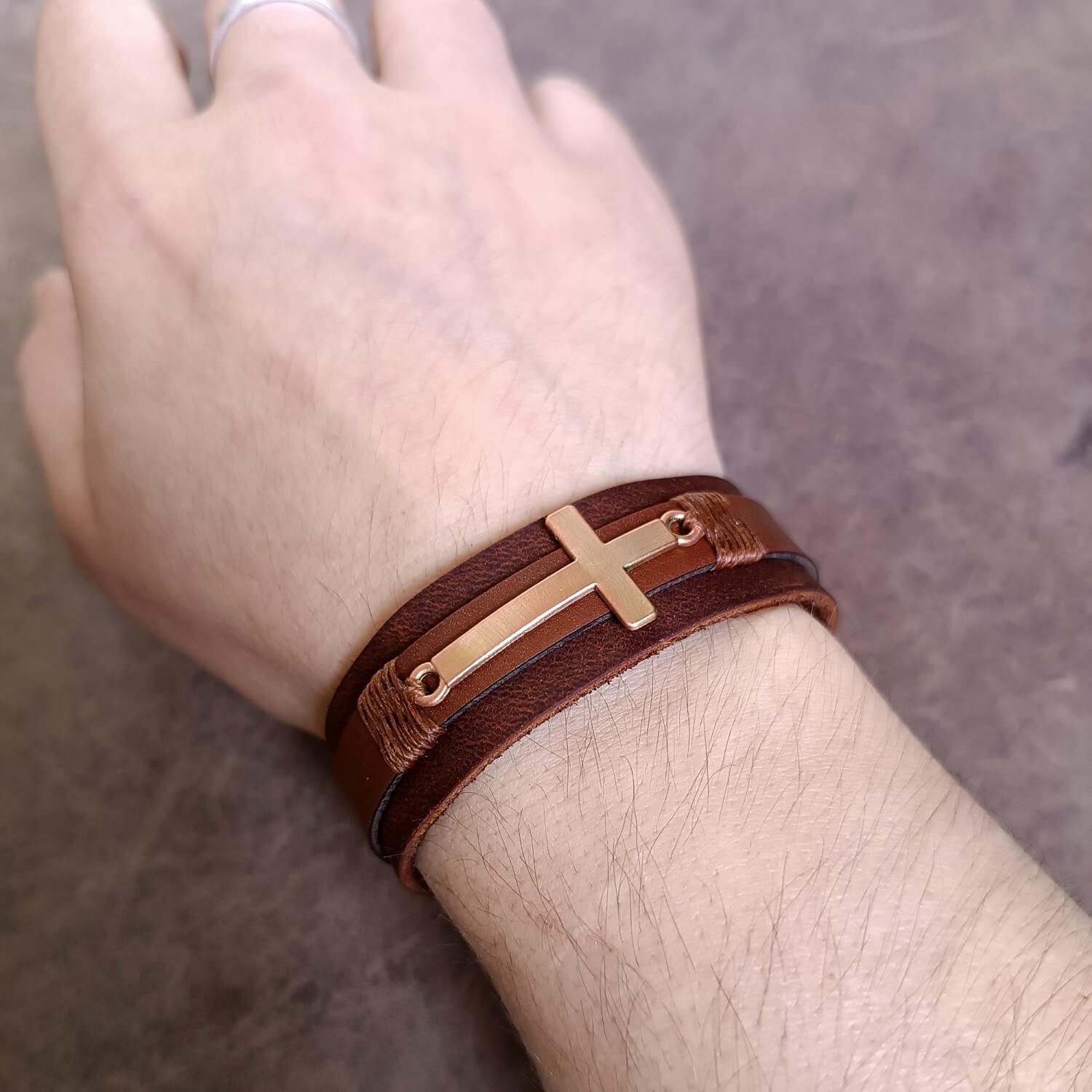 Leather faith cuff worn on wrist, showing genderless and elegant fit