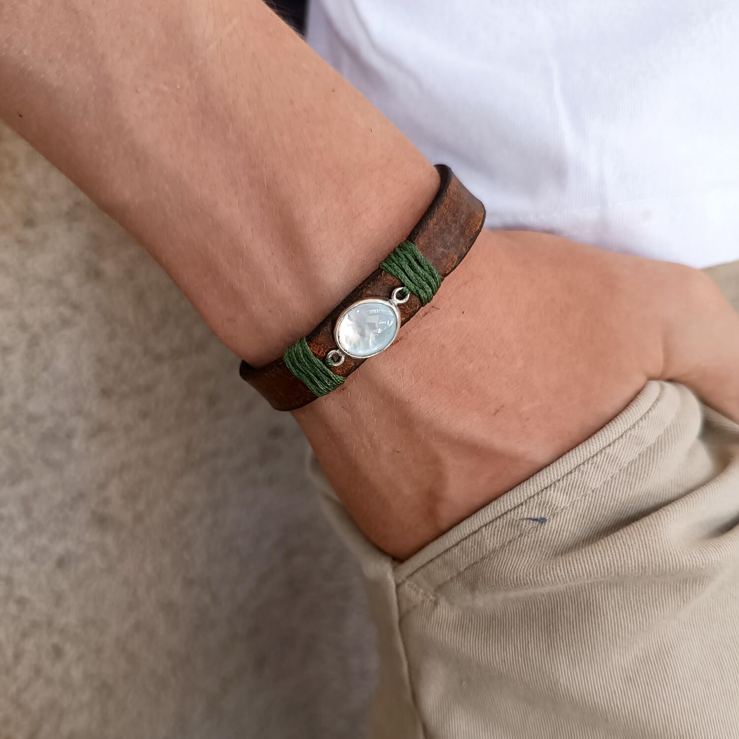 Moonstone Leather Wrap Bracelet worn on a wrist, showcasing the adjustable fit and the elegant glow of the natural moonstone against the dark brown leather. Handmade by Lucky Seven Leather.