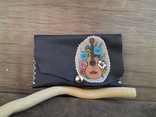 Navy Blue leather wallet with floral guitar design on a wooden surface