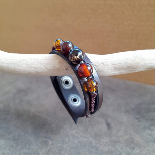The OOAK Amber & Carnelian Beaded Leather Cuff: A chestnut brown full-grain leather bracelet with a prominent row of natural Amber and Carnelian gemstone beads and macramé, designed to look like a bracelet pack.