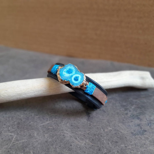 The OOAK Druzy Chrysocolla Leather Bracelet: A layered black and earthy brown full-grain leather bracelet featuring an irregular gold-soldered natural druzy chrysocolla stone, wrapped with blue/turquoise cord.