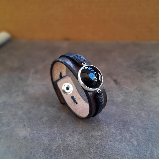 The OOAK Large Black Obsidian Leather Cuff: A layered chestnut brown and black full-grain leather bracelet featuring a prominent large natural black obsidian stone on a sterling silver pendant.