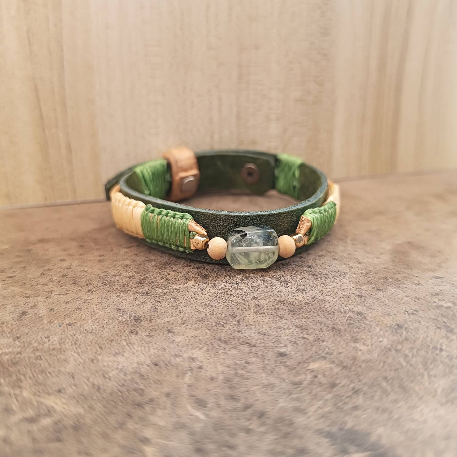 Prehnite gemstone leather bracelet with green and cream braid – front view on leather surface