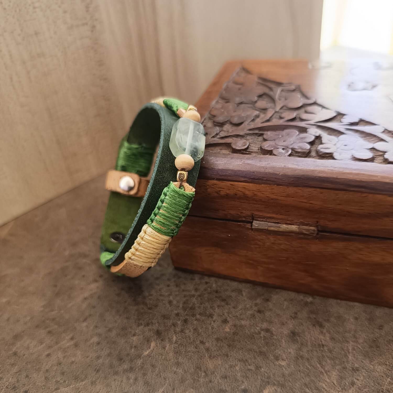 Prehnite bracelet resting on oak jewelry box – calm, earthy boho aesthetic