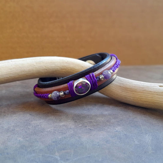 The OOAK Purple Zirconia Bracelet: A layered dark brown and brown leather bracelet featuring a sparkling purple cubic zirconia on a sterling silver pendant, with deep purple macramé and natural amethyst beads.