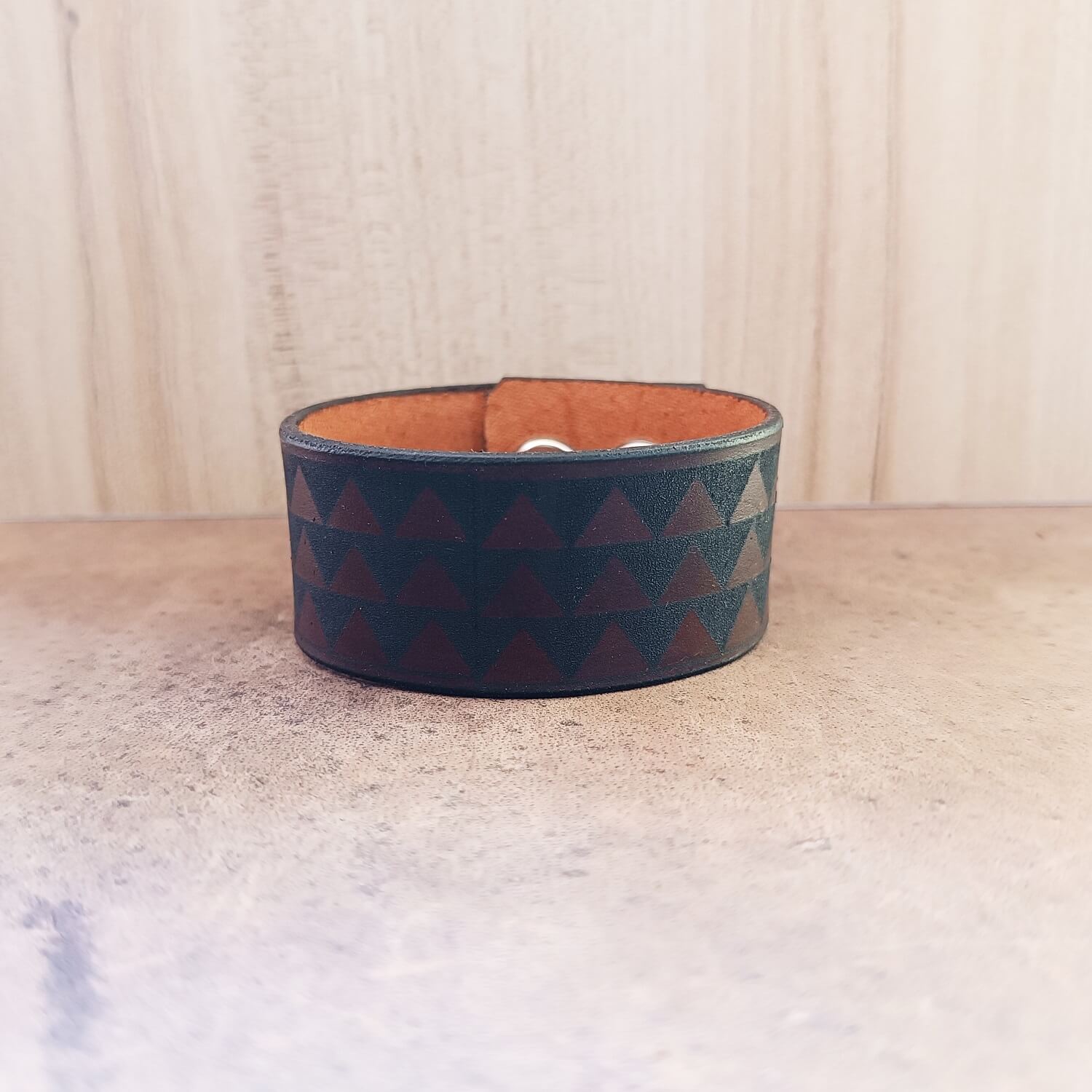 Leather bracelet with samoan tribal engraving on a wooden surface