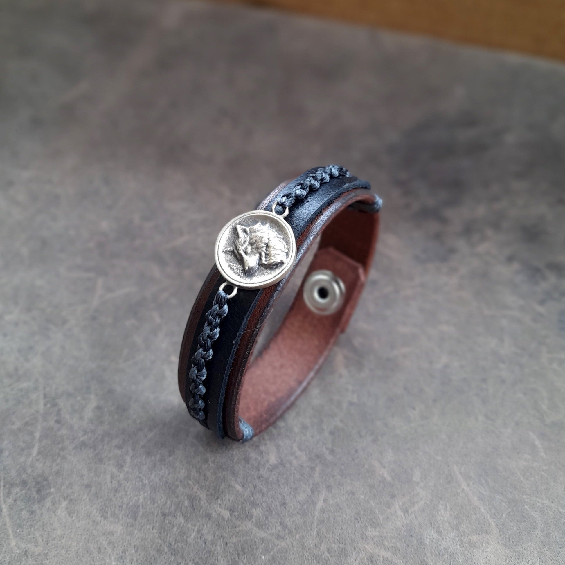 Side view of Great Nordic Wolf Leather Bracelet, revealing the two layers of dark brown and black full-grain leather and the craftsmanship of the bracelet's construction.
