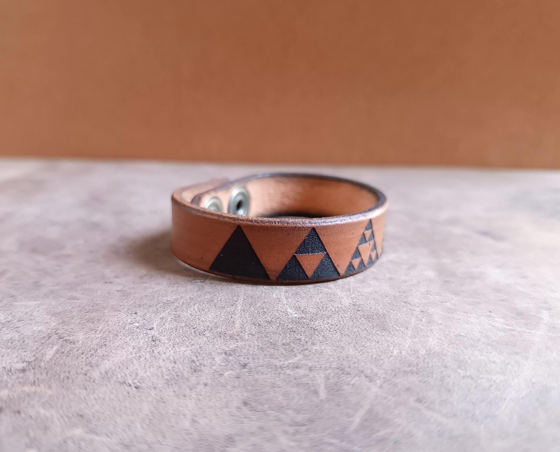Leather bracelet with geometric pattern on a textured surface