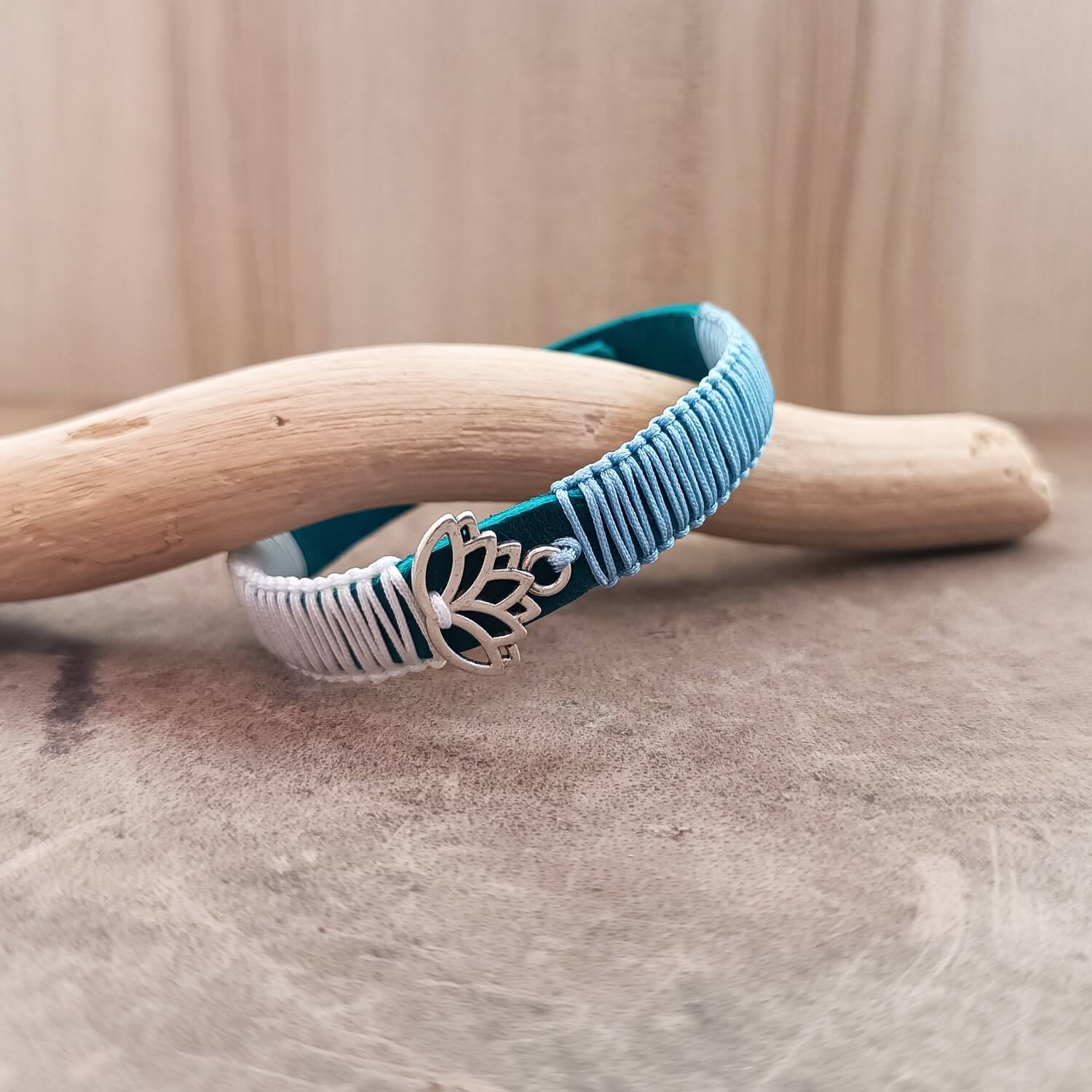 Side view of The Lotus's Serenity Bracelet, showing the thickness of the blue Crazy Horse leather band and the intricate white and light blue macrame knotting.