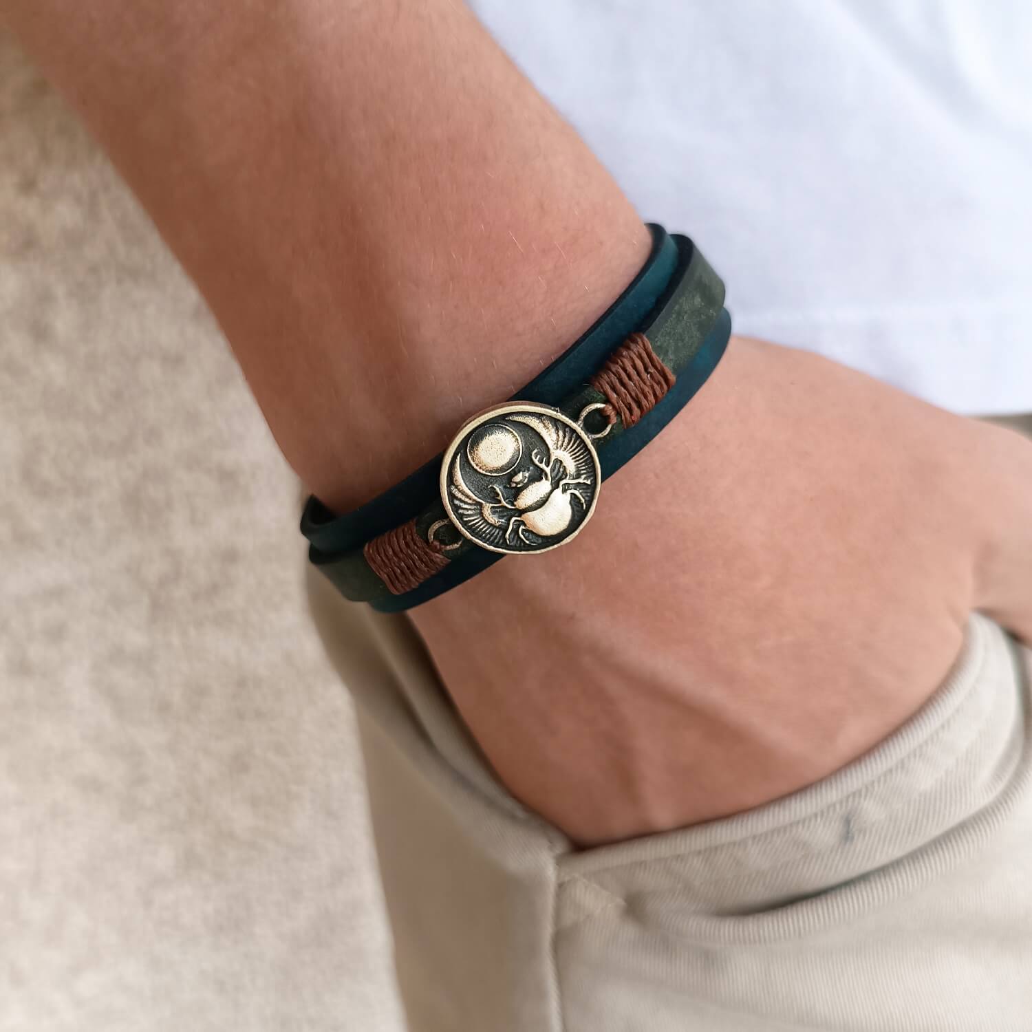 Solar Scarab Bracelet worn on wrist, showing its deep color and symbolic scarab charm. Handmade by Lucky Seven Leather.