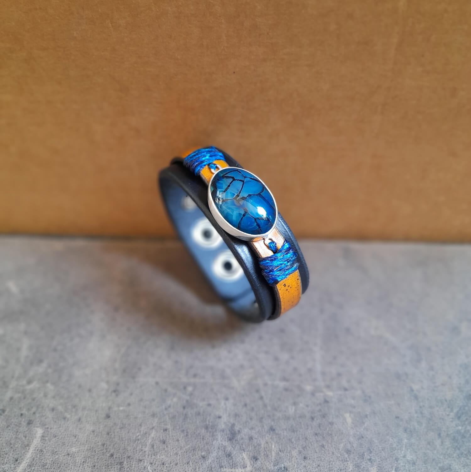 Side view of The Dragon Whisperer Bracelet, showing the two layers of thick full grain leather (black and brown) and the detailed construction.