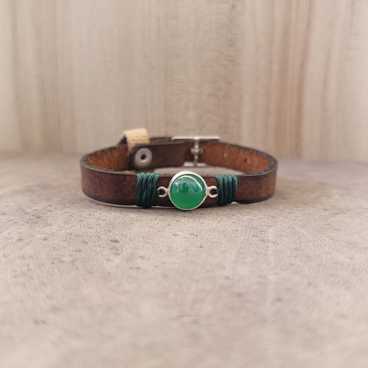 The Forest Whisper Bracelet, a one-of-a-kind minimalist leather wrap bracelet. Shows the rustic brown leather band with a sterling silver pendant holding a green aventurine gemstone.
