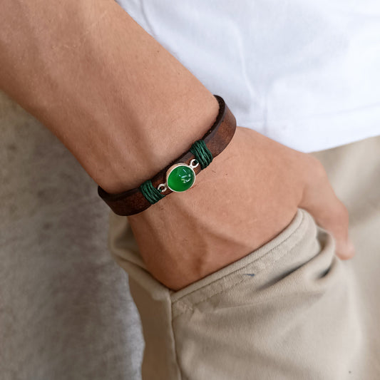 The Forest Whisper Bracelet worn on a wrist, showcasing its minimalist profile, rustic brown leather, and the calming green aventurine gemstone, ideal for everyday wear.