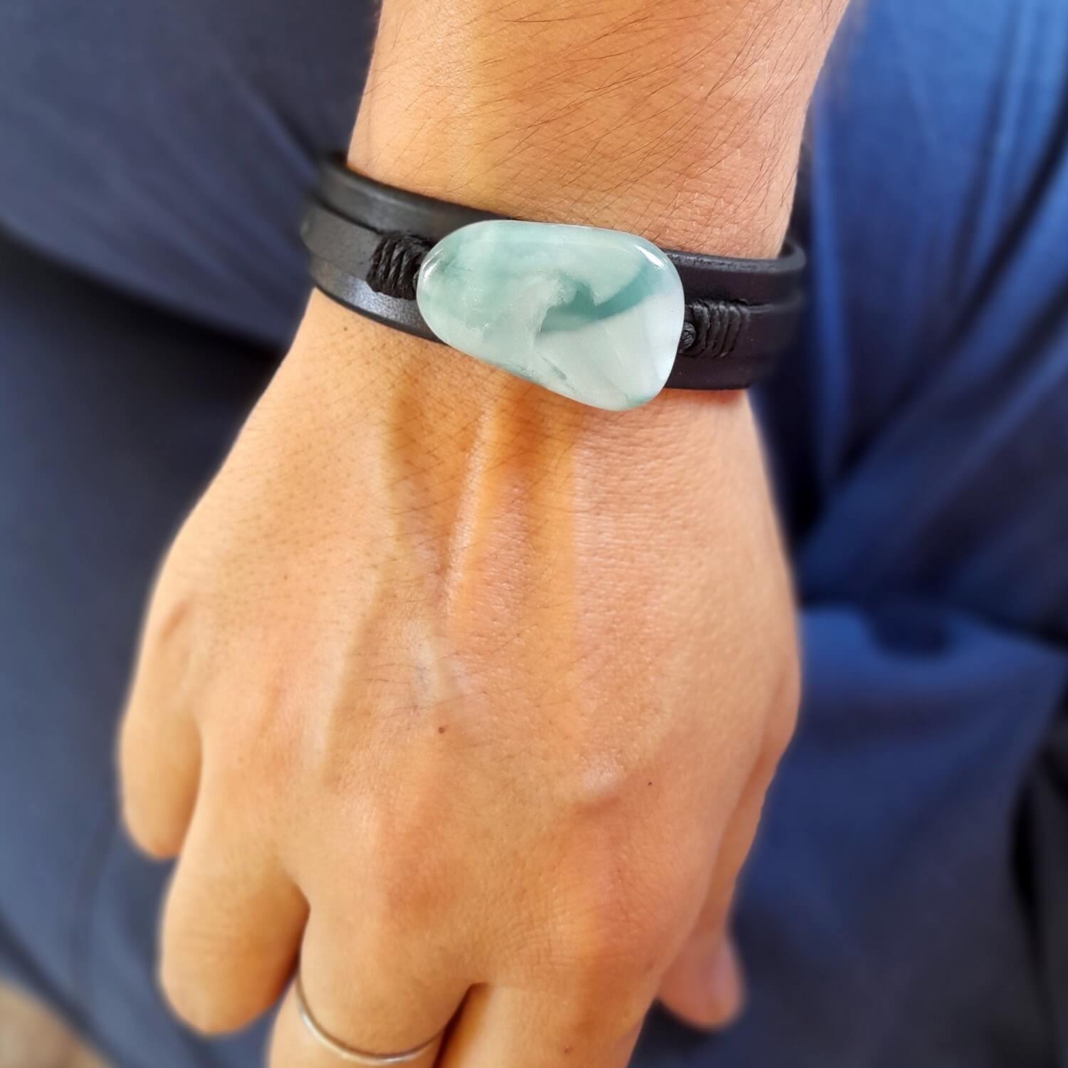 The Green Angelite Black Leather Bracelet worn on a wrist, demonstrating its substantial yet comfortable fit and serene, sophisticated style.