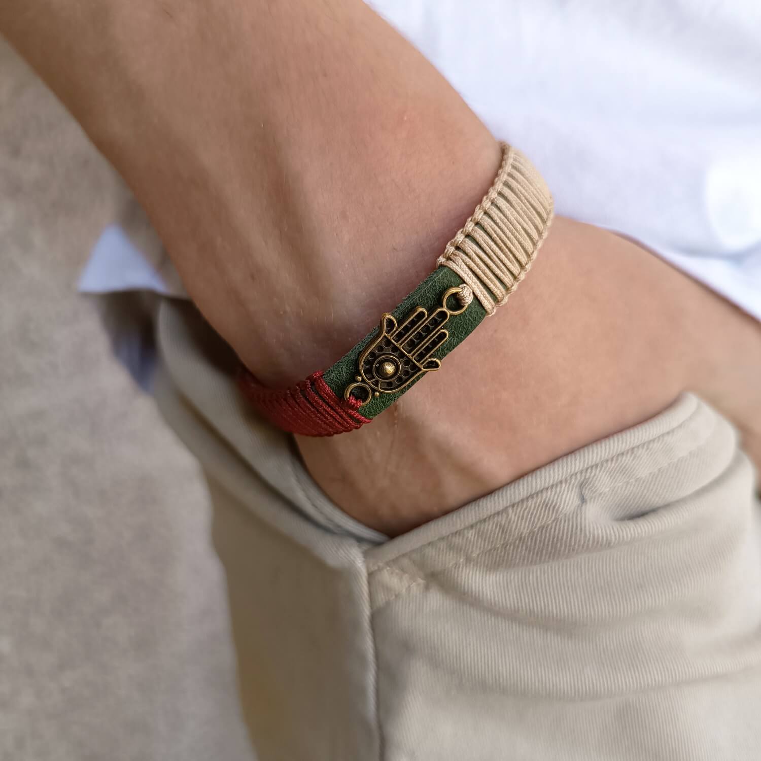 The Hamsa Harmony Bracelet worn on a wrist, showcasing its elegant design, khaki leather, and symbolic Hamsa Hand pendant. Handmade by Lucky Seven Leather's Soulful Echoes Collection.
