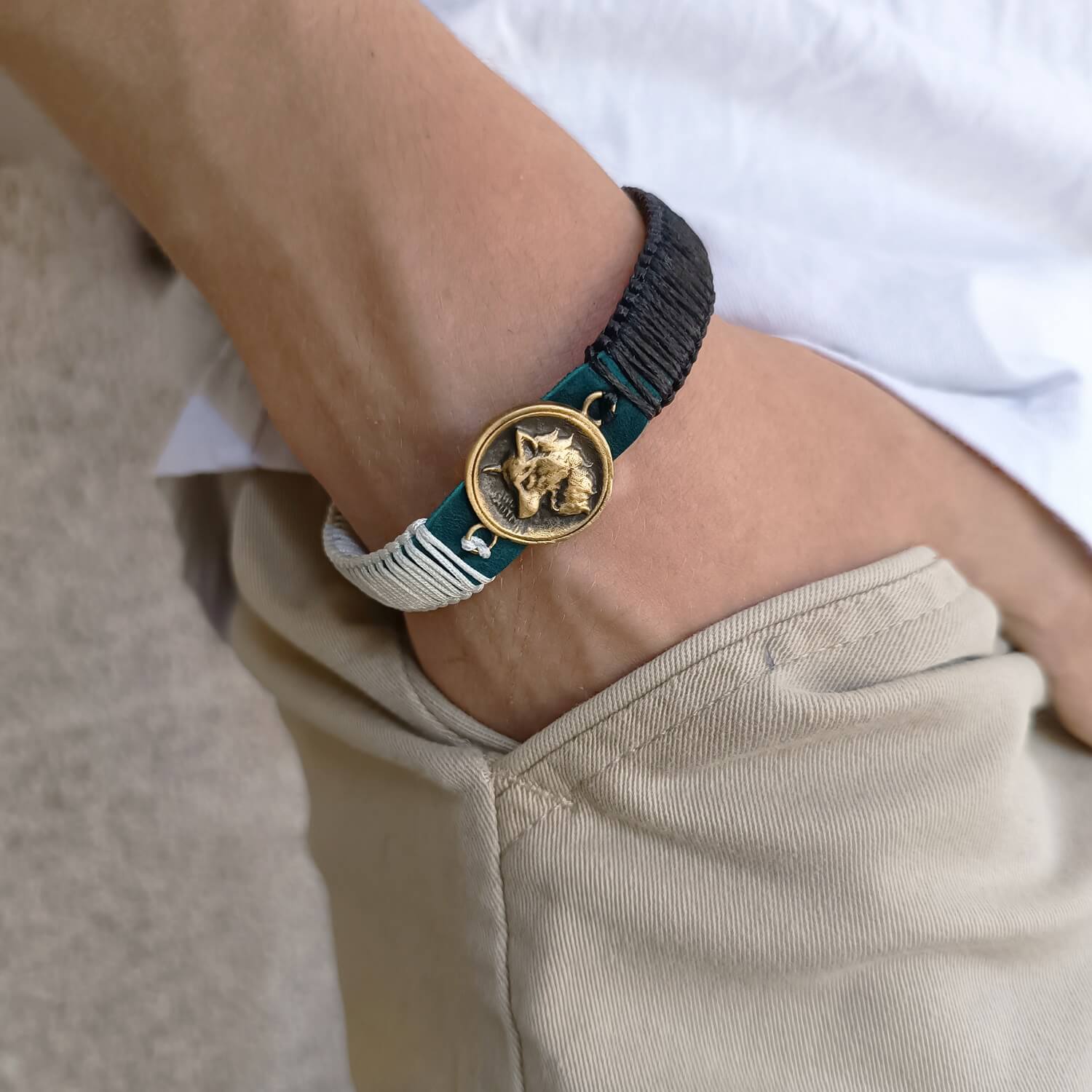 The Instinctive Shield Wolf Bracelet worn on a wrist, showcasing its striking design, deep blue leather, and symbolic wolf pendant. Handmade by Lucky Seven Leather's Soulful Echoes Collection.