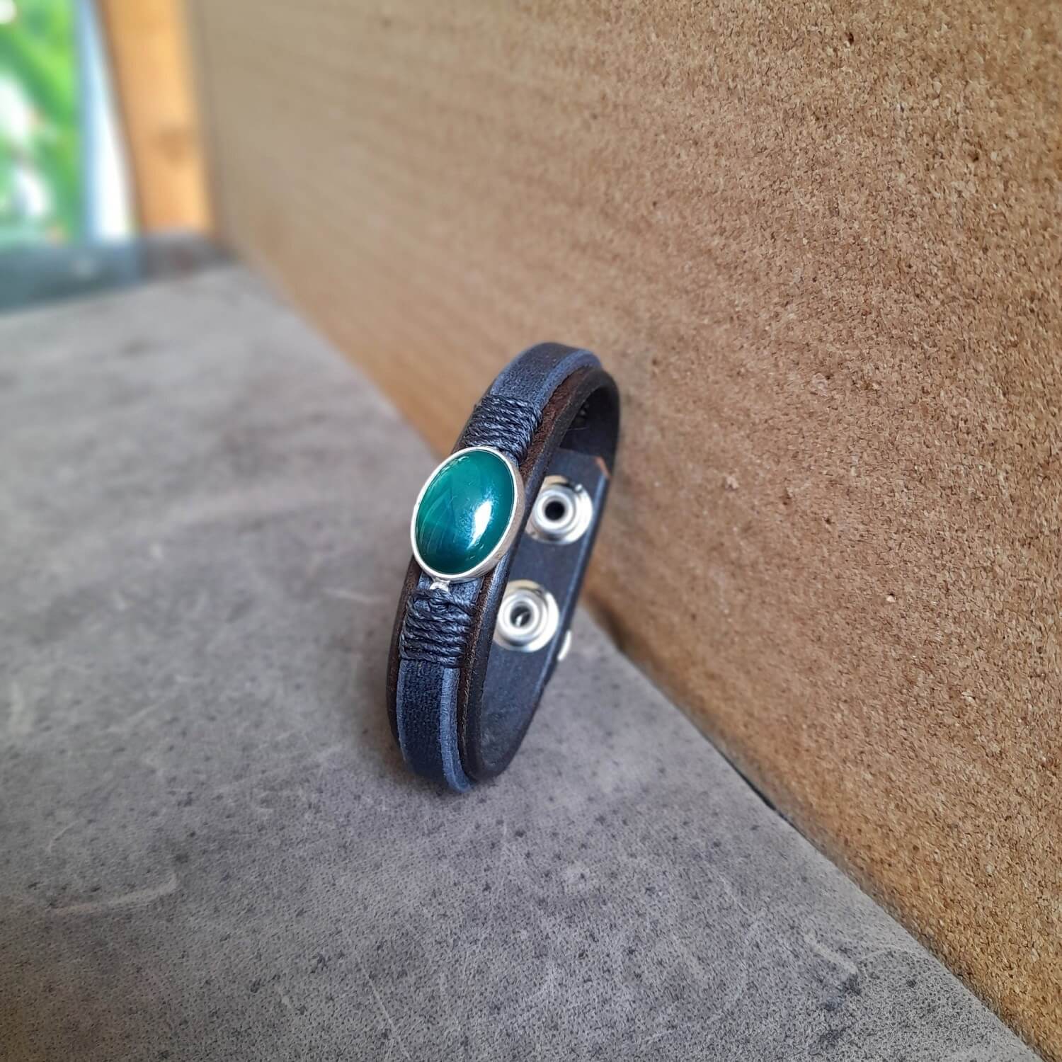 The OOAK Dark Green Aventurine Leather Bracelet: A layered chestnut brown and black full-grain leather bracelet featuring a rare natural dark green aventurine stone on a sterling silver pendant, wrapped with black cord.